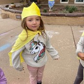 student with cape and crown